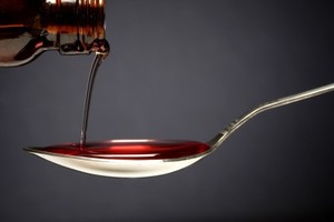 Cough syrup pouring into spoon